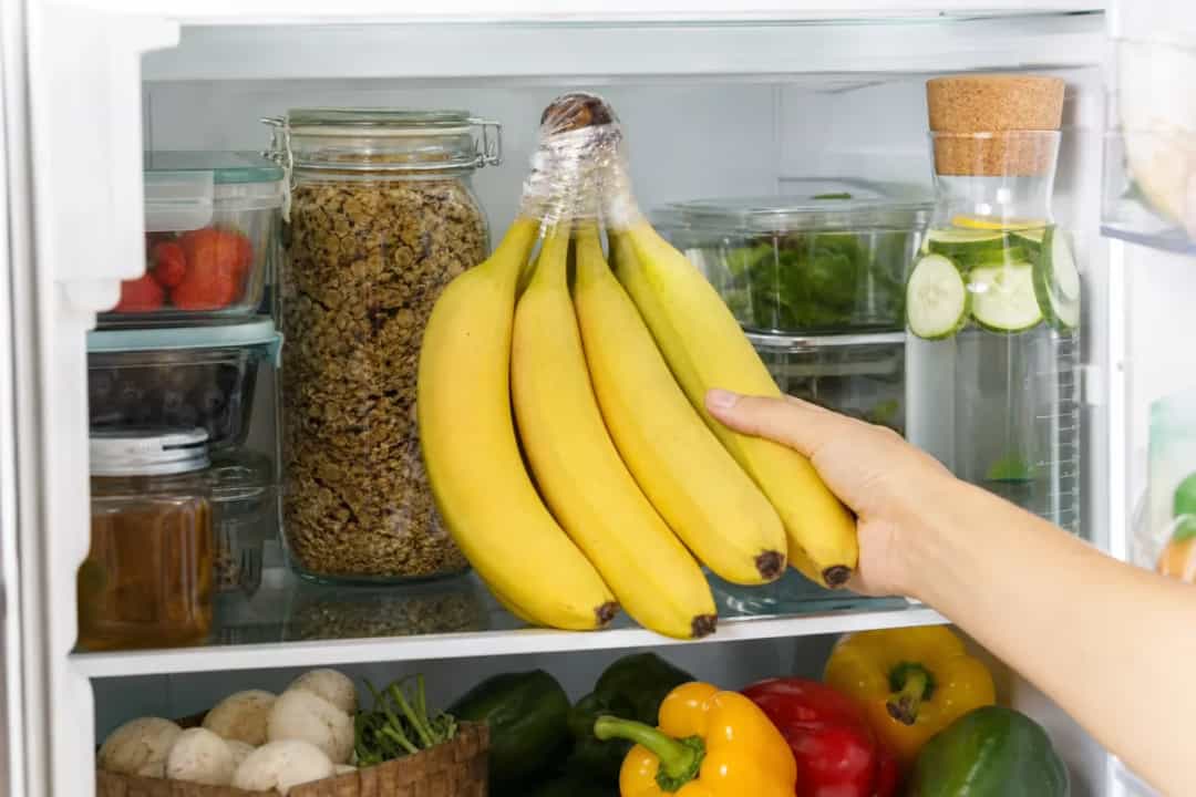 Editorial photo: How to Keep Bananas from Ripening Too Fast (storage organization tip) — realistic home-kitchen scene with visible tools and ingredients in natu