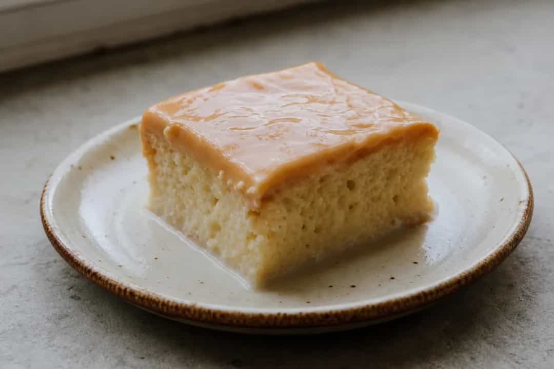 Layers of moist sponge cake soaked in milk and topped with caramel sauce, garnished with nuts.