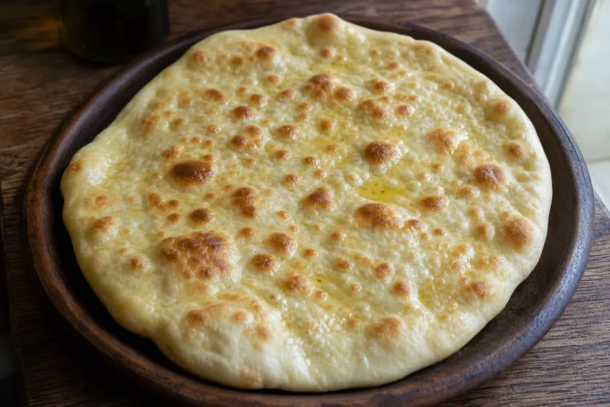 Baked Armenian lavash flatbread with a golden color and soft texture on a wooden board.