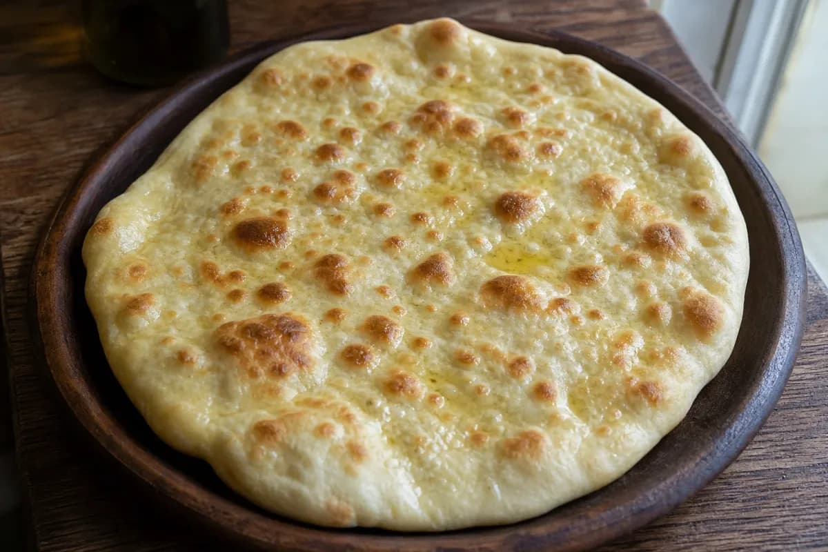 Baked Armenian lavash flatbread with a golden color and soft texture on a wooden board.