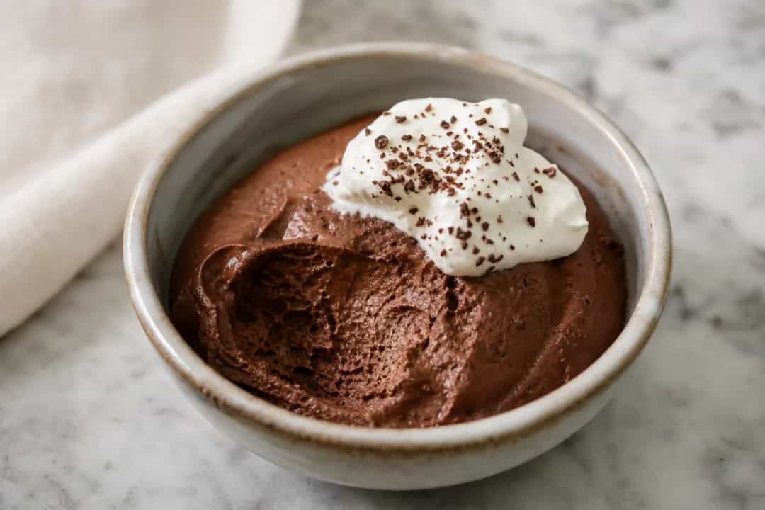 Smooth and velvety Belgian chocolate mousse topped with dark chocolate shavings and served in elegant glasses.