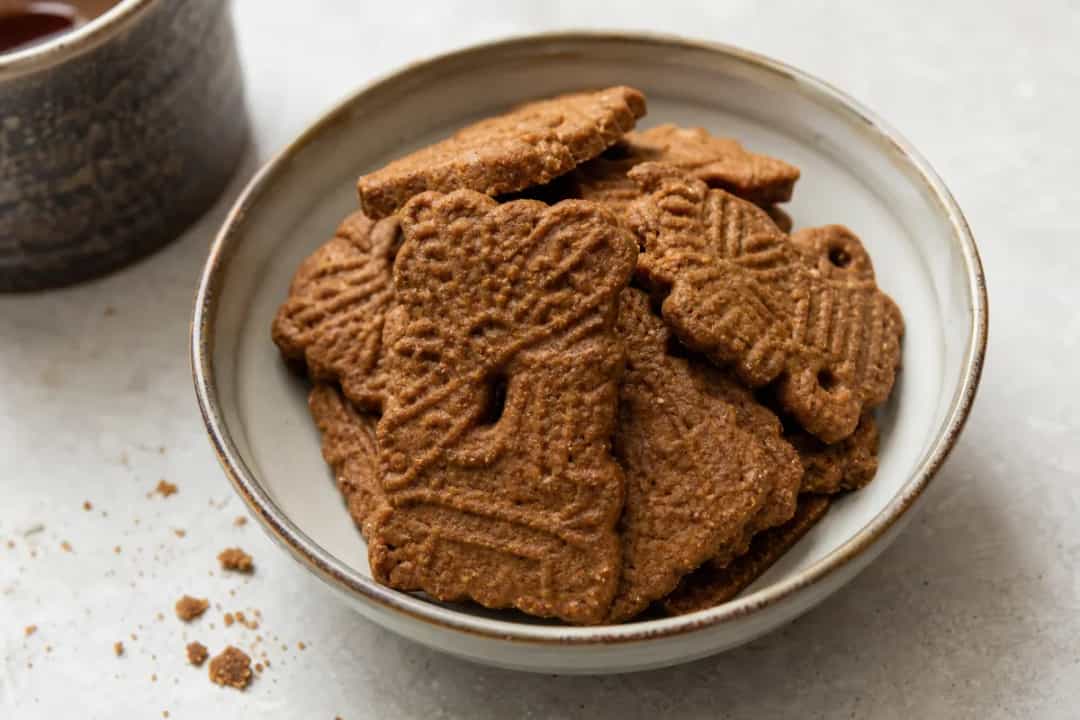Golden-brown speculoos cookies with a spiced surface, arranged on a plate.
