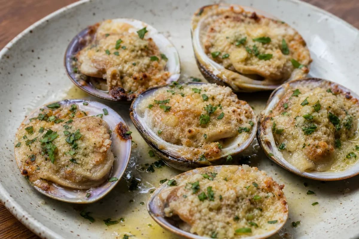 Baked machas topped with melted parmesan, garnished with parsley, served on a white plate.