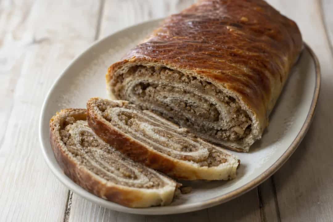 Fluffy Croatian Orahnjača roll with a golden crust, showcasing walnut and cinnamon filling.