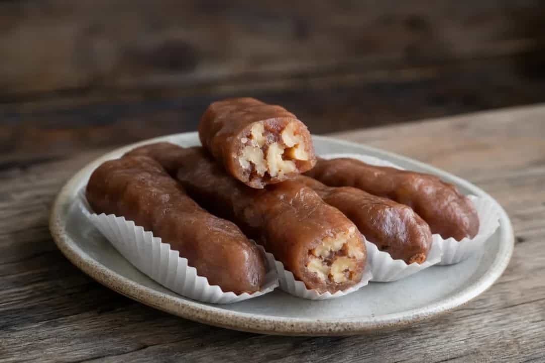 Colorful churchkhela with a glossy grape must coating and walnuts visible inside