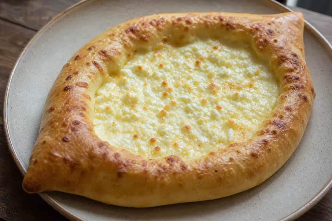 Golden brown cheese-filled bread with a crispy crust, garnished with herbs.