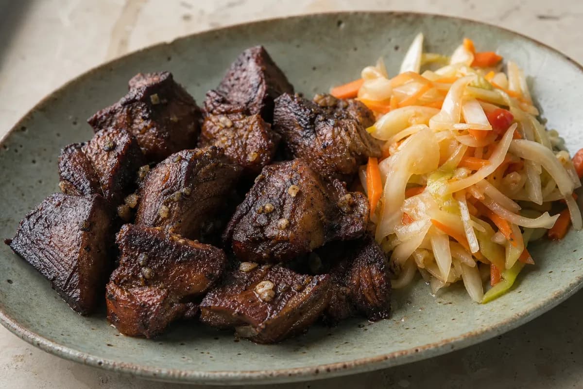 Crispy fried beef served with colorful Pikliz, showcasing vibrant textures and flavors.
