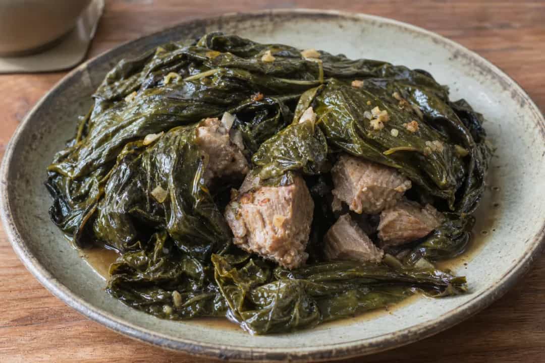 Steamed Lau Lau with moist pork, vibrant green taro leaves, and a hint of Hawaiian herbs.