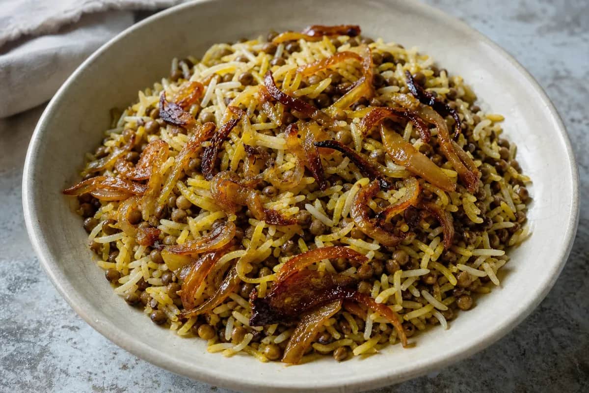 Fluffy rice layered with lentils and golden caramelized onions, garnished with herbs.