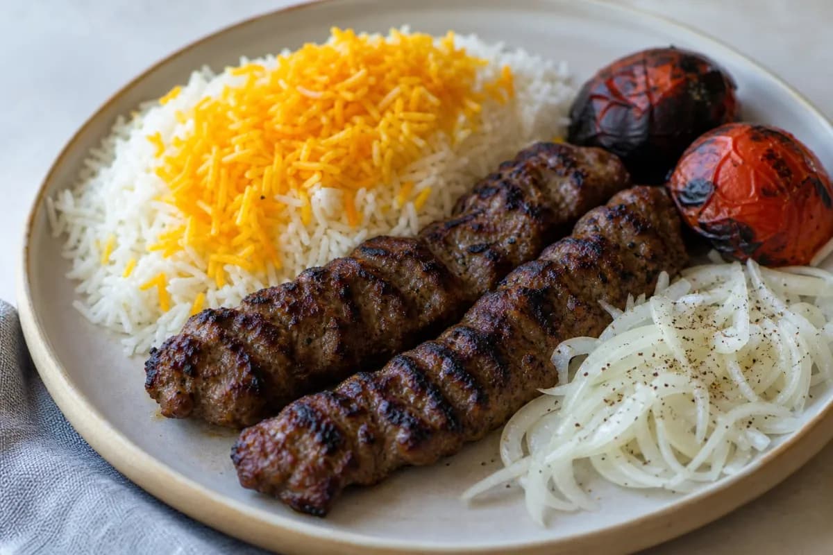 Plated Iranian Koobideh kebabs with saffron rice and colorful grilled vegetables, showcasing vibrant textures.