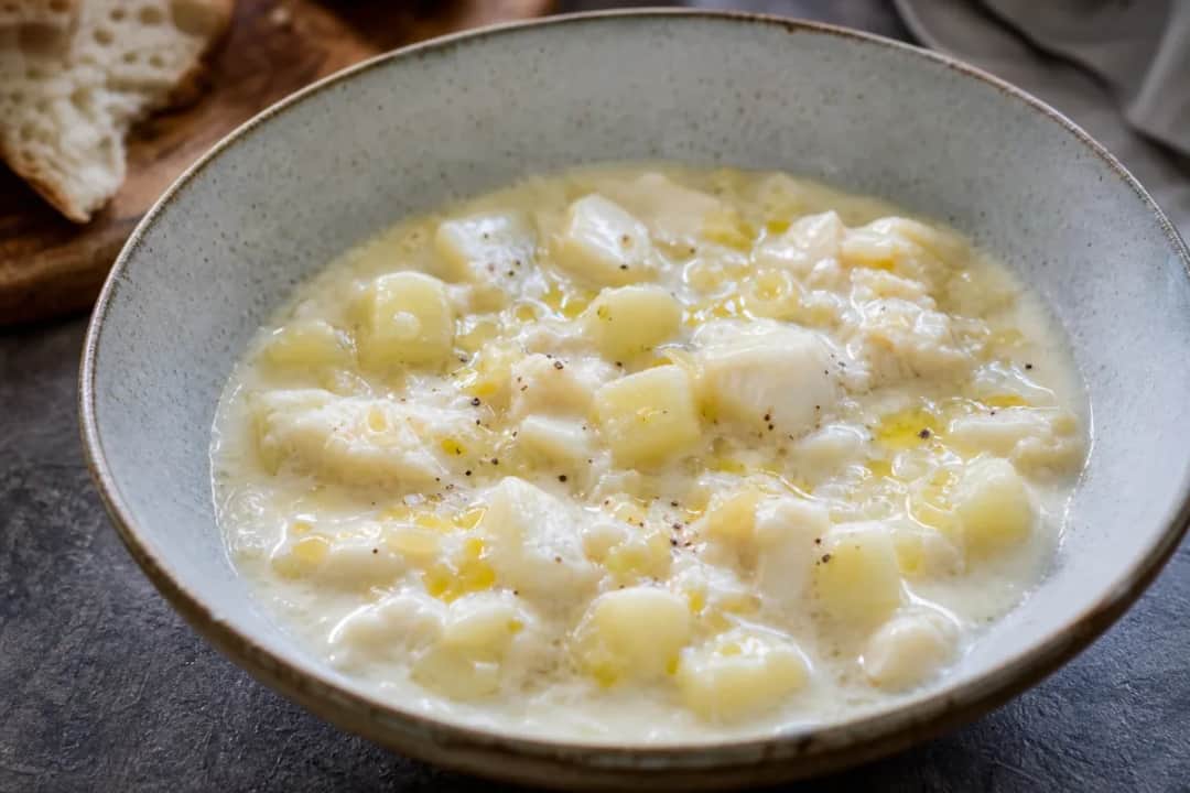 Creamy seafood chowder garnished with fresh herbs and served in a bowl.