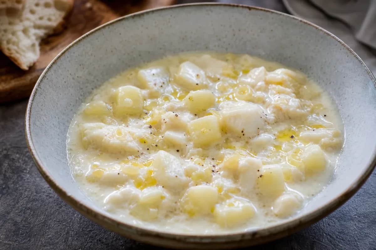 Creamy seafood chowder garnished with fresh herbs and served in a bowl.