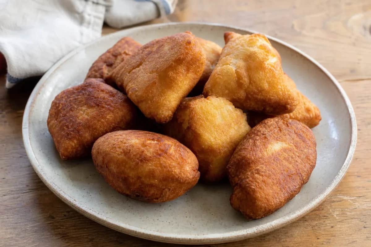 Golden brown Jamaican festival dumplings served with a crispy texture and sweet cornmeal flavor.