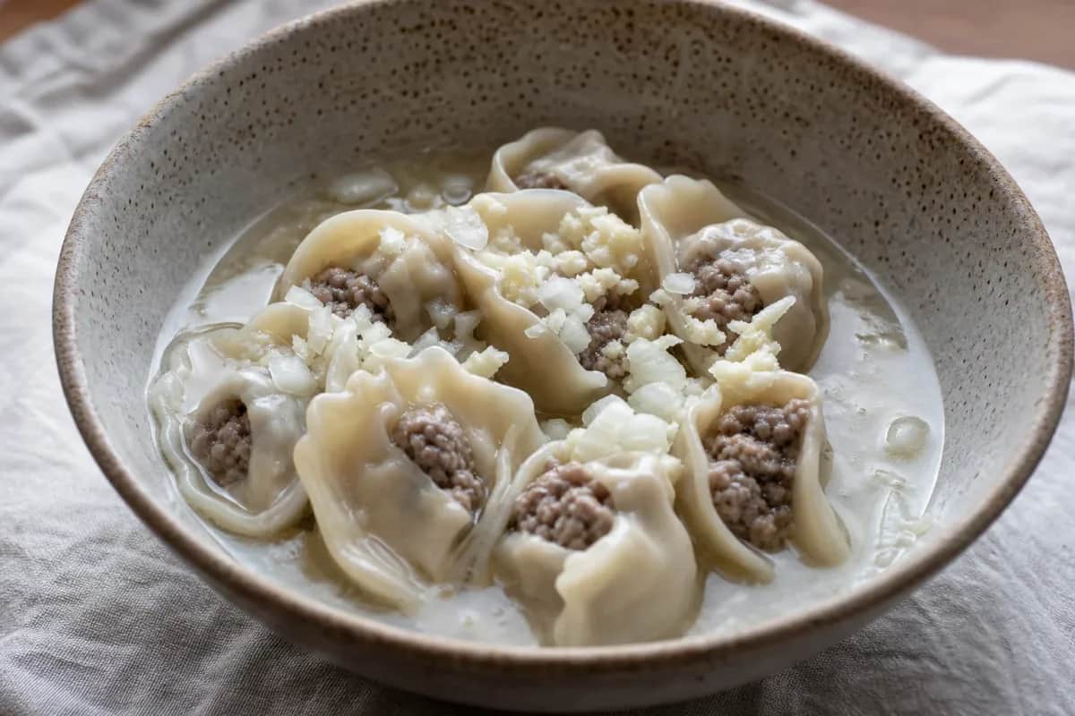 Warm bowl of Mongolian bansh soup with beef dumplings, herbs, and broth.