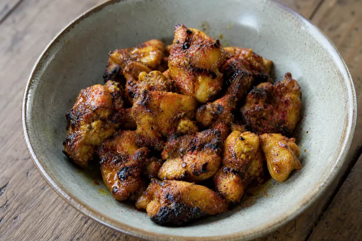 Tender grilled chicken coated in spices, served with fresh herbs and a drizzle of mustard oil.