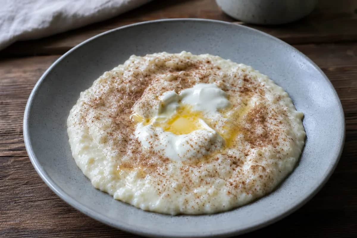 Creamy Norwegian rømmegrøt topped with melted butter and cinnamon in a bowl.
