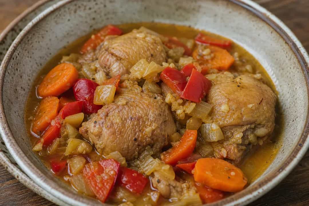 A hearty bowl of Puerto Rican chicken stew with tender chicken, colorful vegetables, and rich sauce.
