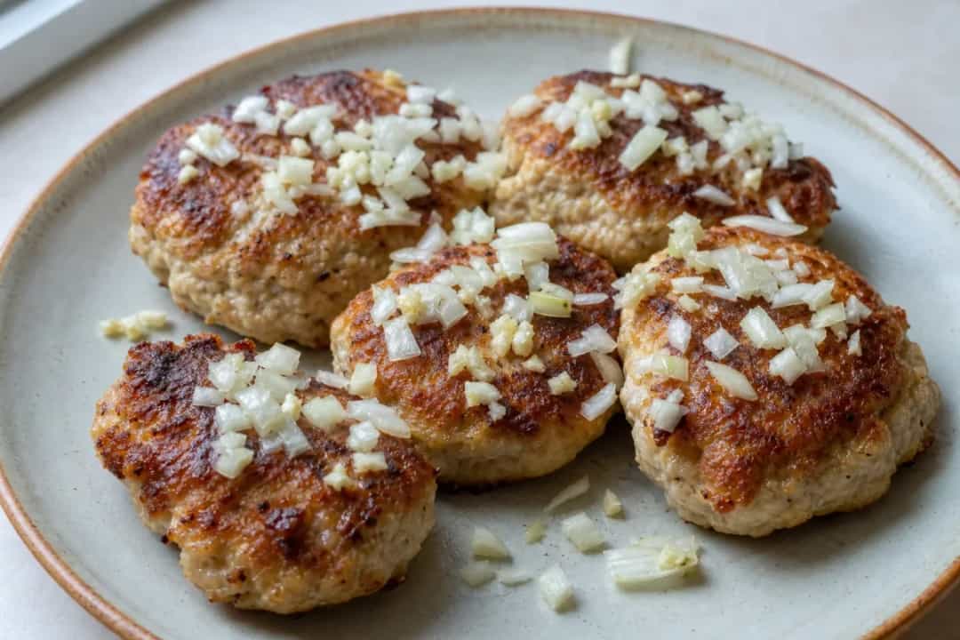 Crispy golden chicken kotleti served with fresh herbs and lemon slices.