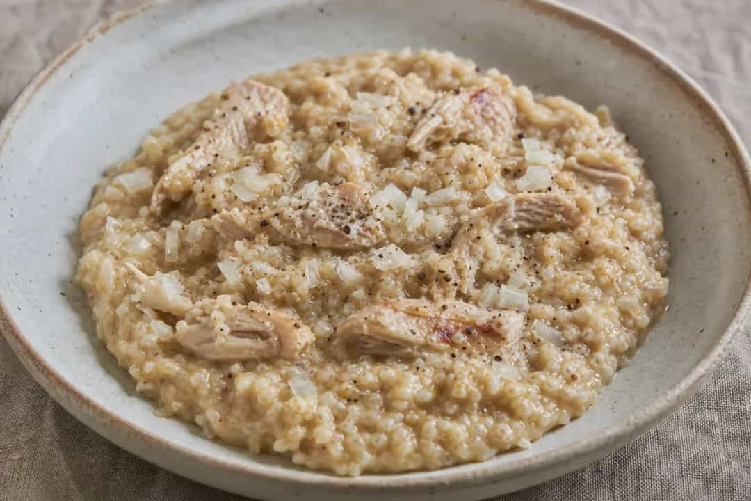 Plated Jareesh featuring creamy cracked wheat and tender shredded chicken.