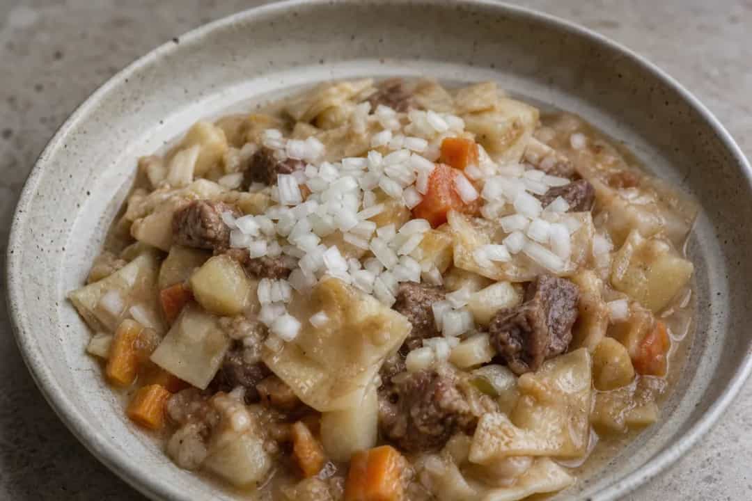 Hearty Saudi matazeez with tender beef, vibrant vegetables, and flat dumplings in a rich broth.