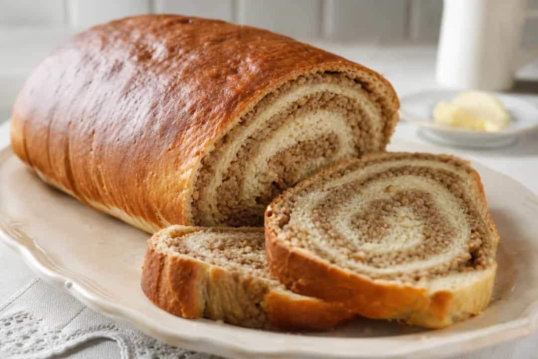 Sliced traditional Slovenian potica showcasing rich walnut filling and golden crust.