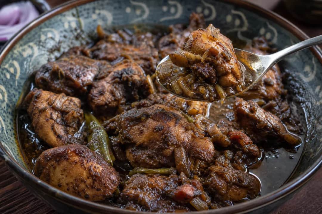 Bowl of Sri Lankan black curry featuring tender meat and roasted spices.