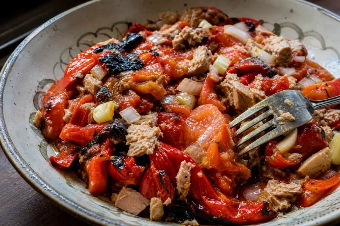 Colorful Tunisian Mechouia Salad with grilled peppers, tomatoes, and tuna served on a plate.