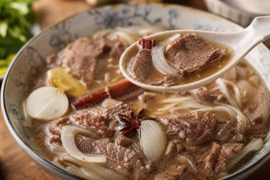 Bowl of Vietnamese beef pho with rich broth, herbs, and sliced beef